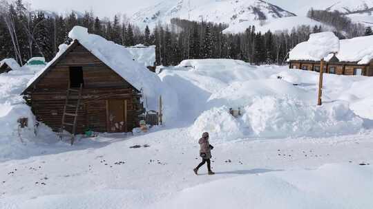 航拍新疆冬季游客在禾木村游玩雪景森林