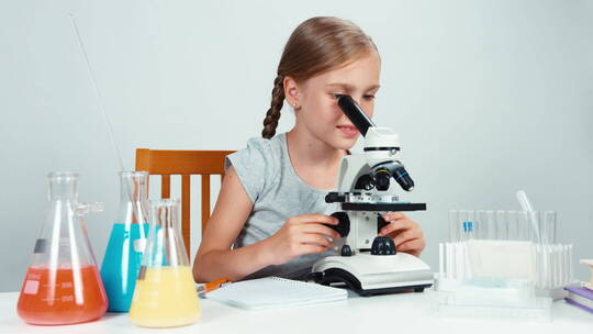 女孩在使用显微镜做实验