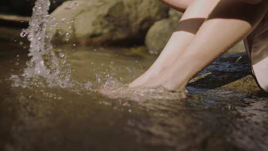 年轻的女性在水里洗脚