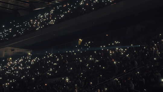 拥挤的音乐厅，黑暗中有灯光的人