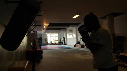 年轻拳击手戴在砖房里训练