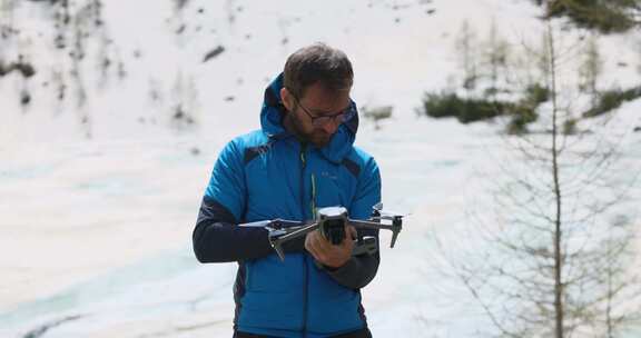 穿着蓝色冬季夹克的男人站在雪地里的户外，