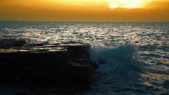 夕阳大海海浪击打礁石