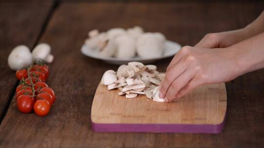 女人在木菜板上切蘑菇