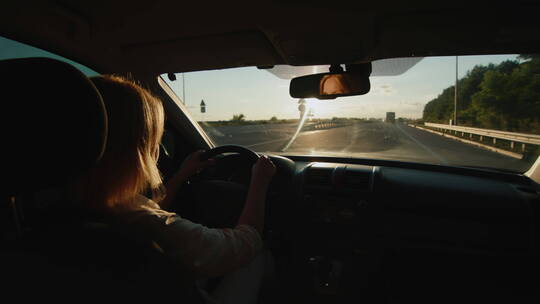黄昏女司机驾车行驶在公路上视频素材模板下载