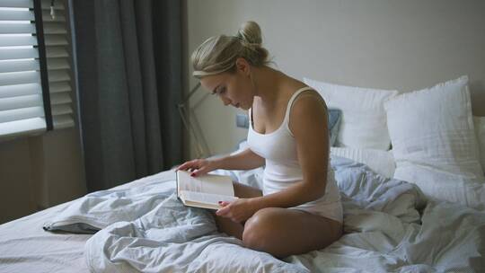 坐在床上看书的女人