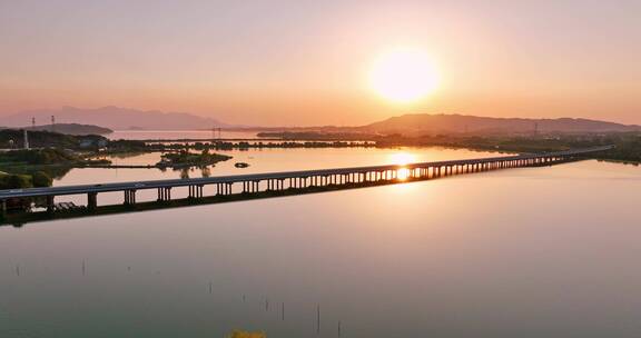 航拍夕阳下穿过鄱阳湖的乡间高速公路