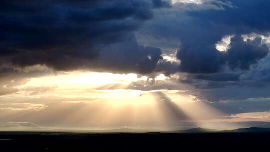 乌云中透出金色光线的天空景象