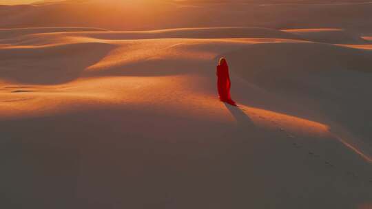 一袭红衣女孩走在沙漠中