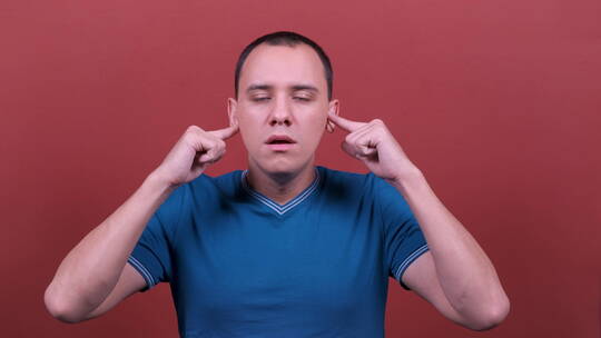男人用手指捂住耳朵摇头视频素材模板下载