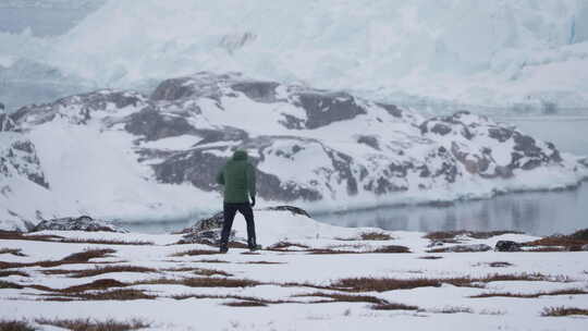 海岸线冰冻荒地徒步旅行的人