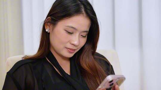 美女躺在沙发玩手机打视频