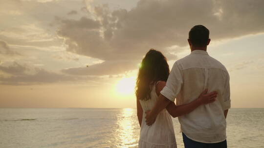 恋爱中的夫妇欣赏海上日落视频素材模板下载