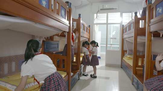小学生整理宿舍内务叠被佩戴红领巾集体宿舍