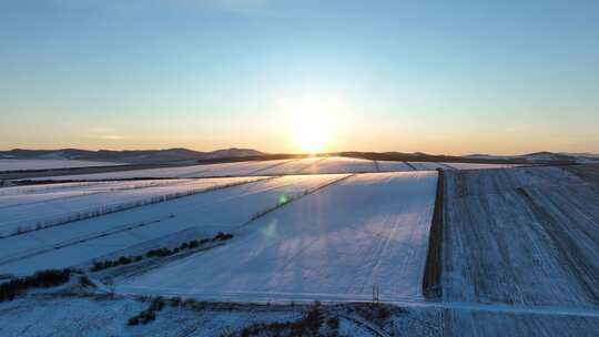 雪后垦区田野夕阳时的美丽景象