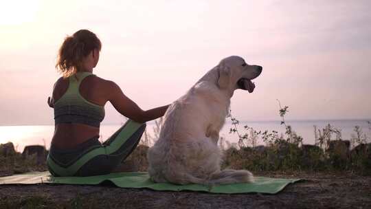 女人带着狗子在海边练习瑜伽
