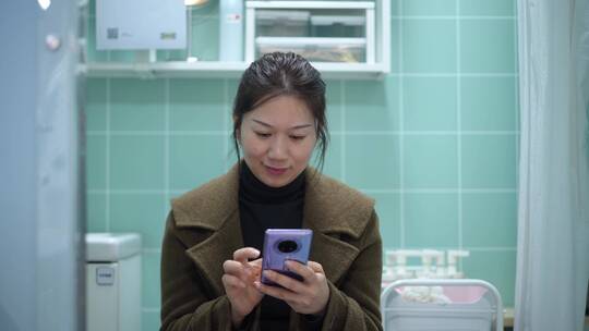 中年女性在卫生间使用手机视频素材模板下载