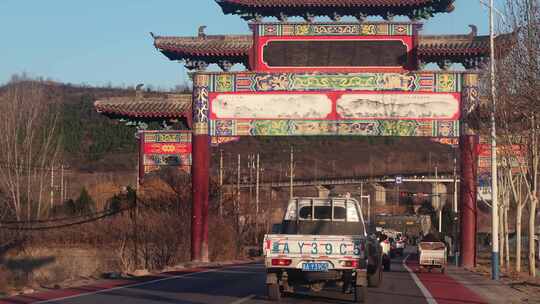 中式牌坊下道路车流景象