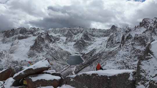 航拍男人坐在莲宝叶则的山顶悬崖边