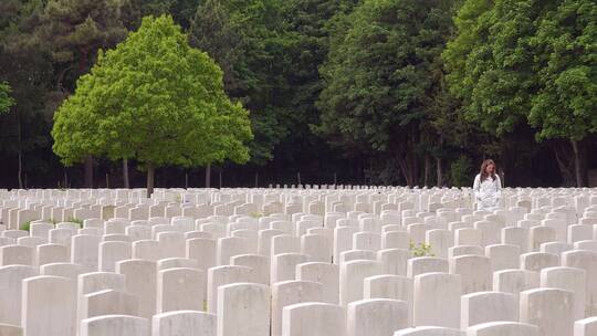 白色外套女人看着埃塔普斯法国二战公墓消失