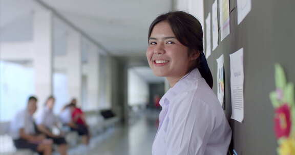 一个穿着白色制服的快乐微笑的亚洲高中生女