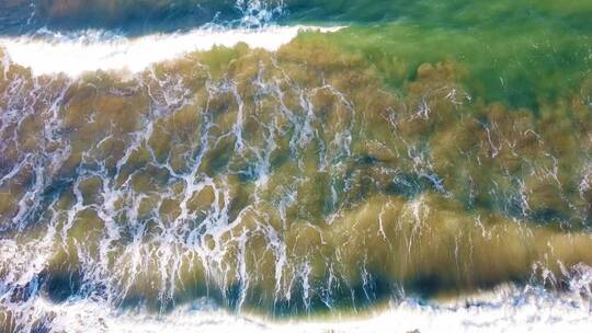蓝色海浪拍打着海边礁石
