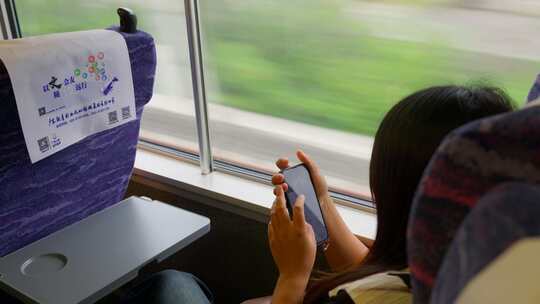 靠在列车窗口玩手机