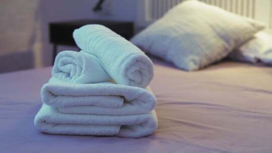 舒适床上整齐卷起的毛巾