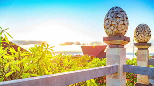 巴厘岛阿梅德海滩日出与海面背景下的灯笼花卉图案雕塑沙石