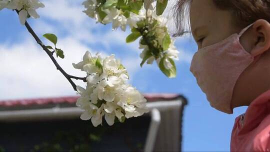 戴着面具的孩子闻着花外面的过敏病毒 (2)