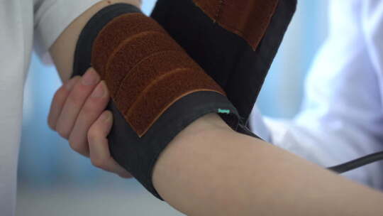 医生用血压计测量女性患者的血压，特写