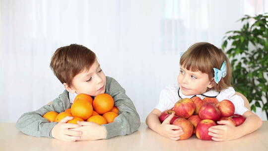 在桌上抱着水果的小孩