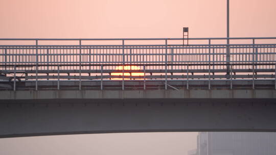 轻轨列车在高架桥上驶过夕阳的慢镜头特写