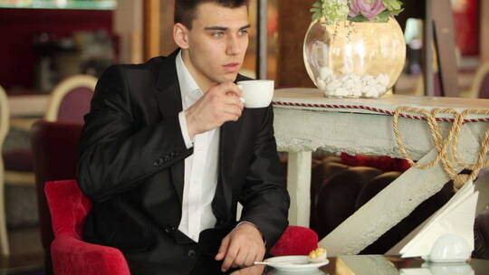 穿西装的男人在咖啡馆里喝咖啡