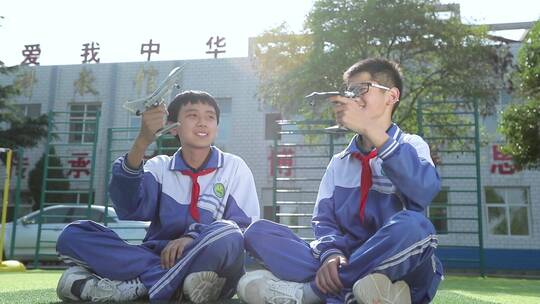 两个男孩学生挥舞着航模飞机视频素材模板下载