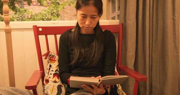 女性室内坐摇椅看书场景