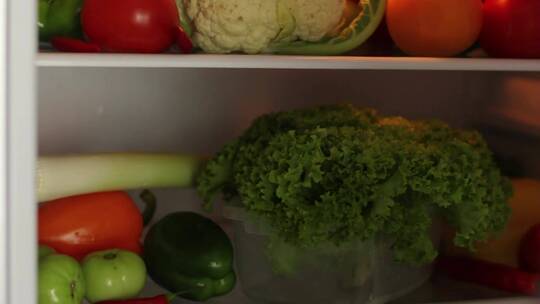 女人从冰箱里拿出了蔬菜