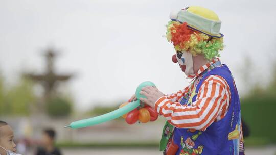小丑在给孩子吹气球
