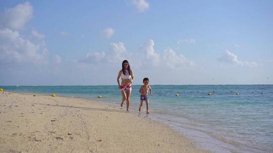 泳衣妈妈和孩子海边沙滩快乐奔跑