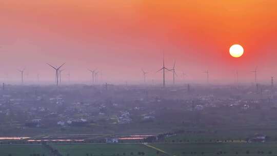 航拍夕阳落日太阳风力发电站群村庄农户平原