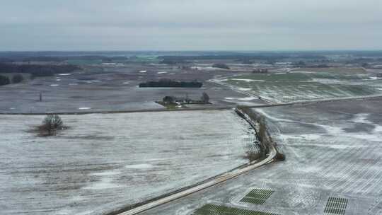 冬季冻土农田和乡村砾石路树线鸟瞰图