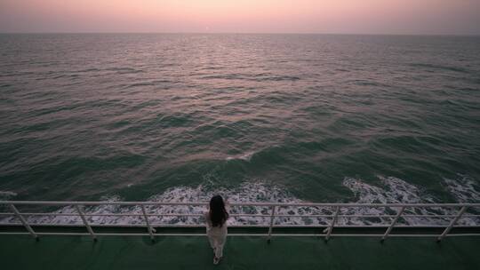 年轻女孩在轮船甲板上看海上夕阳视频素材模板下载