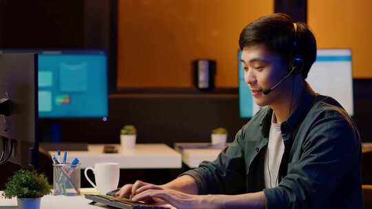 男士戴耳机在办公室操作电脑