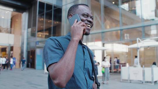 非洲黑人青年走在成都街头开心打电话视频素材模板下载