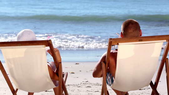 情侣在海滩上喝鸡尾酒视频素材模板下载