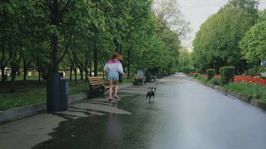 带着狗在公园跑步的女人