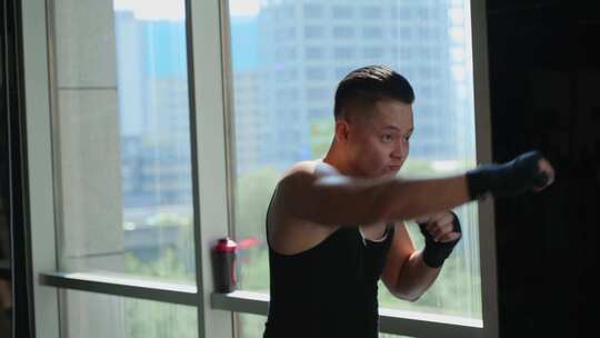 年轻男人在健身房锻炼身体练习拳击