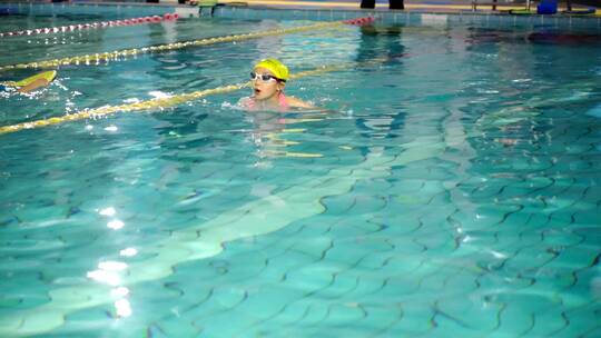 游泳池中练习游泳的中国女孩