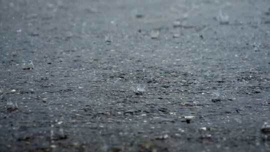 暴雨下雨雨滴落在地面上溅起水花