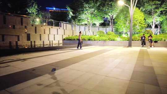 夜晚公园广场玩滑板车的年轻人视频素材模板下载